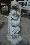 A weathered composite garden ornament modelled as a young lady.
