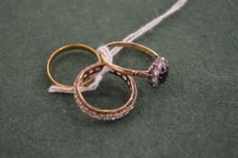 A gold wedding band and two rings.