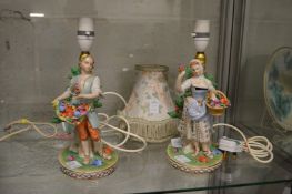 A pair of continental porcelain figural lamps with shades.