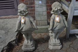 A pair of composite garden ornaments modelled as young girls.