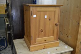 A small pine bedside cupboard.