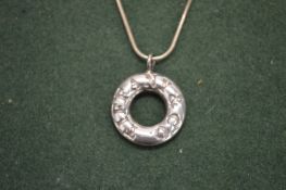 A silver pendant and chain.