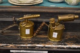 Two old brass blow lamps.
