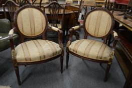 A pair of French style carved mahogany framed open armchairs.