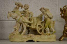 A porcelain centrepiece depicting two children and a cart being pulled by a goat.
