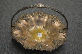 A plated swing handle basket with grape and vine decoration.