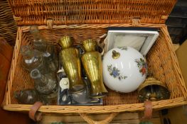 A wicker basket containing miscellaneous collectables to include a pair of brass vases.