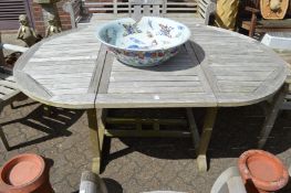 A weathered teak garden table.