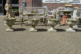 A set of four weathered composite garden planters.