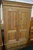 A pine two door wardrobe with drawers below.