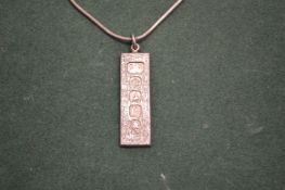 A silver ingot pendant and chain.