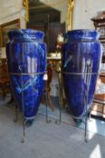 A large pair of faux marble amphora style vases in wrought iron brackets.
