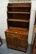 A 19th century mahogany cupboard bookcase with waterfall style open shelves above a drawer and two