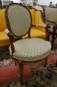 A French style mahogany and parcel gilded and upholstered open armchair.