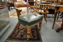 A Victorian oak and leather upholstered library armchair.