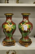 A pair of cloisonne vases on stands.