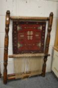 A small loom with part made Persian rug.