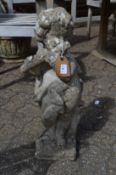 A weathered composite garden ornament modelled as a cherub playing a flute.