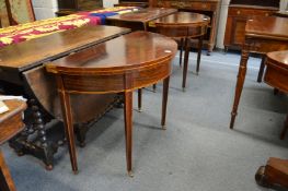 A pair of mahogany demi-lune foldover card tables on tapering square legs.