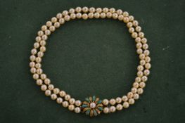A pearl two row choker with gold and turquoise set clasp.