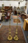 A pair of turned brass floor standing lamps.