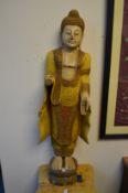 A carved and painted wood Thai standing figure.