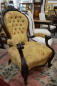 A Victorian button upholstered mahogany framed open armchair.