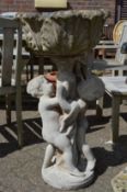 A large pedestal garden planter the base modelled as two cherubs.