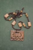 A Chinese carved hardstone amulet and chain.