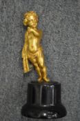 An ormolu bronze putti on a wooden stand.