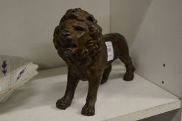 A cast metal model of a lion.