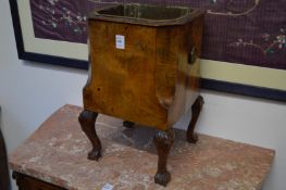 A walnut jardiniere with brass liner on cabriole legs.