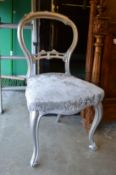 A silver painted dining chair.