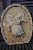 An amusing garden wall plaque, modelled with a flying pig.