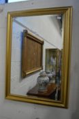 A gilt framed wall mirror.