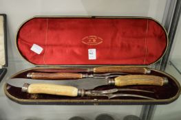 A cased four piece stag handled carving set.