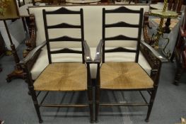 A pair of Arts and Crafts rush seated armchairs.