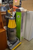 A Dyson upright vacuum cleaner and a Tower fan.