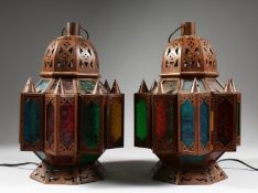 A PAIR OF NORTH AFRICAN METAL OCTAGONAL LANTERN with coloured glass panels. 14ins high.