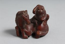 A JAPANESE CARVED WOOD NETSUKE HORN AND MONKEY. 1.75ins. Signed.