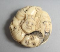 A MANY FACED BONE NETSUKE, 1.25ins diameter.