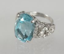 A LARGE AQUAMARINE RING with diamond shoulders.