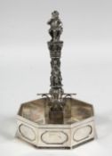 A 19TH CENTURY PLATED RING STAND as a column with garlands and figures with octagonal base. 8ins