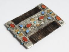 AN ISLAMIC SILVER COMB set with coloured stones, 9cm long x 7cm wide.