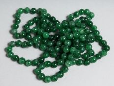 A STRING OF JADE BEADS 52ins long.