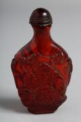 A CARVED AMBER SNUFF BOTTLE AND STOPPER.