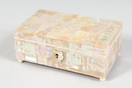 A SMALL SHELL CLAD SILK LINED, JEWELLERY BOX on ball feet. 4.5ins x 2.5ins.