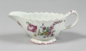 A BOW FLUTED BUTTER BOAT painted with coloured flowers.