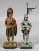 TWO NOVELTY LIGHTERS, a man in armour and a Scottish Highlander. 10ins high.