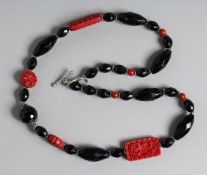AN ONYX AND CARVED CORAL. 22ins long.